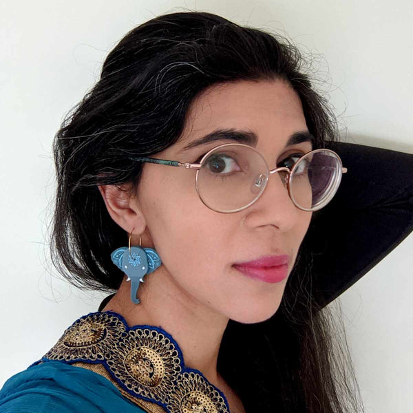 woman wearing blue grey elephant acrylic hoop earrings