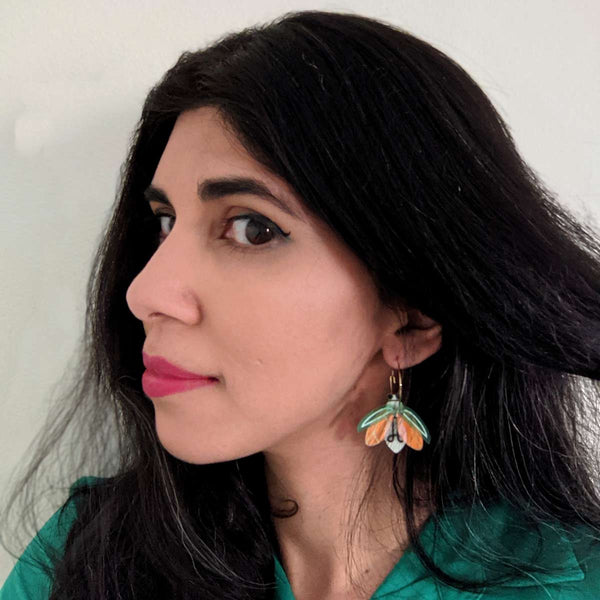 woman wearing glow in the dark firefly acrylic hoop earrings