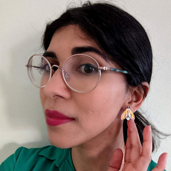 woman wearing glow in the dark firefly acrylic stud earrings