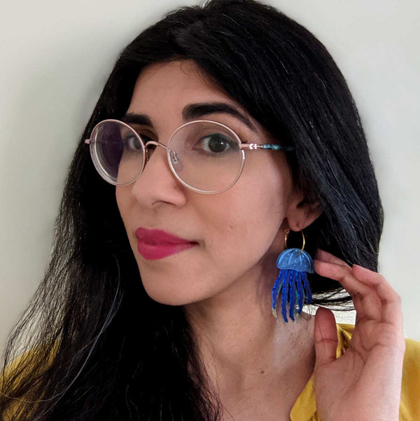 woman wearing blue jellyfish acrylic hoop earrings