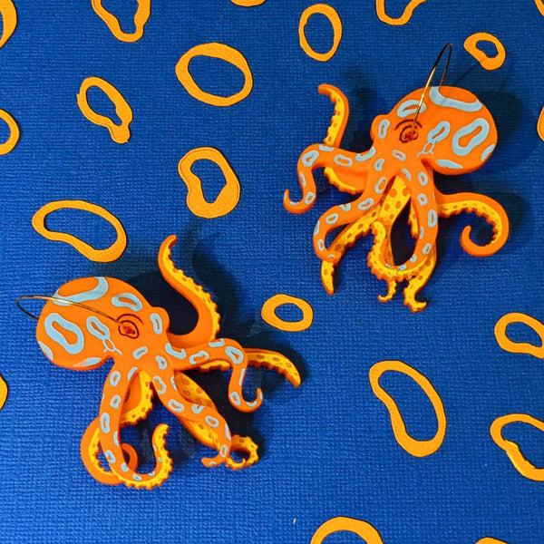 Quirky earrings featuring acrylic blue ringed octopus on gold hoops