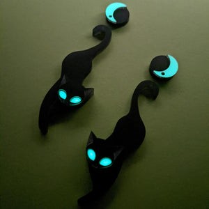 Black cat with glowing eyes beneath a crescent moon jewellry