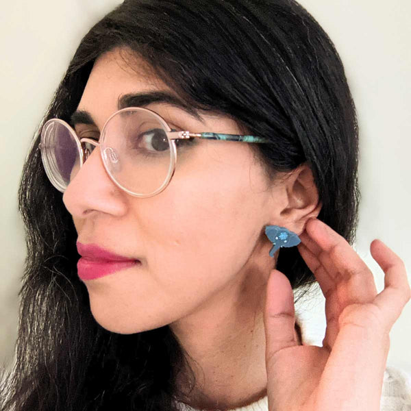woman wearing blue grey elephant acrylic stud earrings